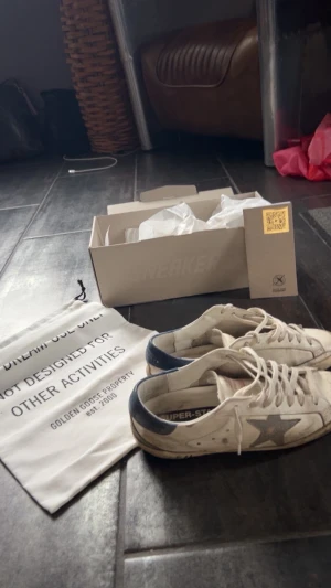 Golden Goose  - ‼️Säljer nu dessa Golden Goose skor som är unika och rätt sällsynta med text på sulan. Röda detaljer och en blå sula. Allt OG tillkommer. Anledningen till det billiga priset är ju givetvis det ganska slitna skicket på skorna. Sulan är ju lite förstörd. Men går ju självklart att laga! Vid frågor eller funderingar skriv gärna. Strl 40 passar 41. (Se skadan på sista slide) accepterar billigare än vad ni tror