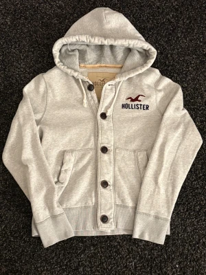 Hollister cardigan - sjukt eftertraktad! - Säljer nu denna sjukt eftertraktade hollister cardiganen. Skick 8/10, sjukt snygg och passar perfekt nu till lite kyligare dagar. Obs kan gå ner i pris vid snabb affär!