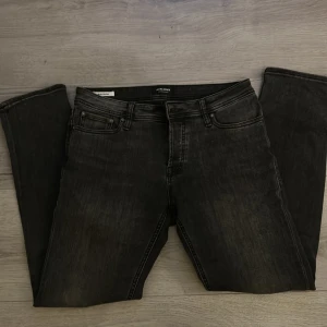 Svarta jeans från Jack & Jones, 32/32 - Snygga svarta jeans från Jack & Jones med klassisk femficksdesign och diskret tvättad look. Jeansen har rak passform och normal midja, tillverkade i slitstarkt denim. Perfekt för dig som gillar stilrena och tidlösa jeans.