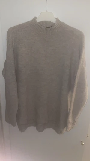 Beige stickad tröja Vero Moda XS - Mysig beige stickad tröja från Vero Moda i storlek XS. Tröjan har en rundad hals med ribbad kant och långa ärmar. Perfekt för att hålla sig varm under kyliga dagar och passar till jeans eller kjol för en chill look.