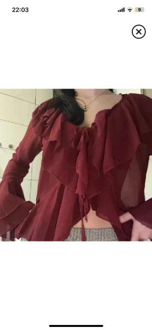 Perfekta jul/nyårblusen🎄 - Supersnygg vinröd blus med volanger och v-ringning. Långa, vida ärmar med vilanger och knytning framtill ger en romantisk vibe. Tunt, lätt material som faller fint och känns luftigt. Perfekt för dig som vill sticka ut med en elegant och trendig look. Strl M men sitter super på xs/s se bilderna🙂 Superfin till middag fest jul/nyår🥂🥂