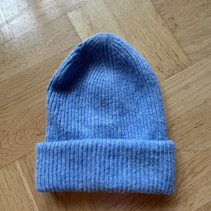 Ljusblå ribbad stickad mössa - Säljer en snygg ljusblå ribbstickad mössa med uppvikt kant.