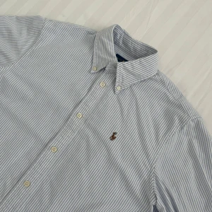 Ralph Lauren skjorta - Sjukt fet Ralph Lauren skjorta med stiliga ränder✨Skick: Mycket bra✨Storlek: M men sitter som S✨Färg: Vit och ljusblå🤍🩵✨Tveka inte på att höra av dig vid frågor eller funderingar🙌🏼