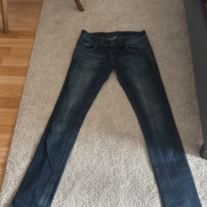 Mörkblå skinny jeans från Amisu - Snygga mörkblå skinny jeans från Amisu med slitningar och klassisk femficksdesign. Jeansen har låg midja och smal passform upp till och lätt utsvingning nertill. Materialet är stretchigt jeans för extra komfort.