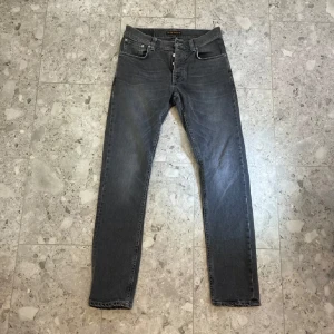 Nudie jeans Grim Trim - Säljer ett par mörkgråa Nudie jeans som har modellen Grim trim, färgen är helt perfekt nu på hösten 🍂 Storleken är W30/L32. Skicket på jeansen är 10/10.    🟢Mitt pris: 400kr  🔴 Nypris: 1600kr