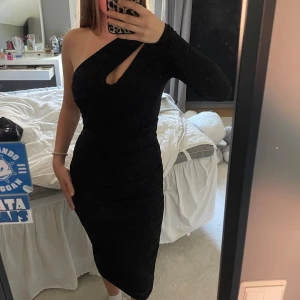 Svart oneshoulder klänning NA-KD XS - Säljer en svart oneshoulder klänning från NA-KD i storlek XS. Klänningen har lång ärm på ena sidan, aldrig använd🤍