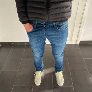 Dondup George  - Säljer ett par klassiska blå jeans från dondup i storlek 34. Jeansen har normal passform, fem fickor och snygga kontrastsömmar. Perfekt tvättad blå färg och diskret dondup-logga på bakfickan. Sköna och stilrena jeans som funkar till det mesta.