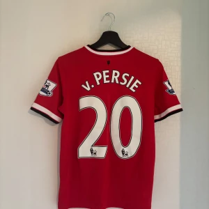 Manchester United fotbollströja Van persie  - Manchester United fotbollströja från säsongen 14/15 med Van Persie 20 på ryggen. Originalprodukt, Premier League-patches och Ikonisk Nike-design Storlek Xl barn men passar bra som xs/s herr.  Skick: Bra – några små dragningar i tyget samt ett lätt skadat tryck på ryggen, men det syns endast på nära håll. Inga större defekter. Perfekt för samlare eller United-fans som vill ha en klassisk tröja i garderoben! 🔴⚫⚪