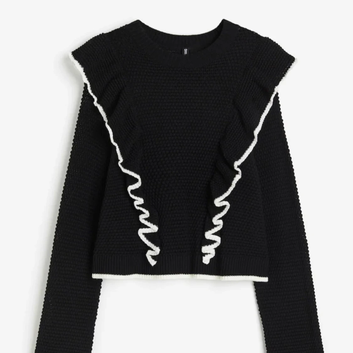 Svart stickad tröja med volangdetaljer