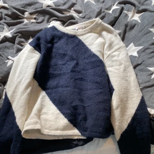Blåvit stickad tröja från Gina Tricot - Mysig stickad tröja från Gina Tricot i storlek 170. Tröjan har ett coolt diagonalt mönster i mörkblått och vitt, med rund halsringning och långa ärmar. 