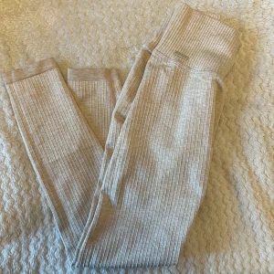 Ribbade leggings från Aim'n i beige - Superbekväma ribbade leggings från Aim'n i en ljusbeige nyans. Hög midja och stretchigt material som sitter snyggt och följsamt. Perfekta för chill eller träning, med diskret Aim'n-logga på höften. Säljes i storlek S.