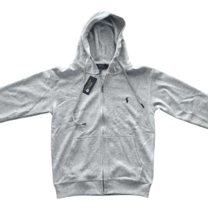 Grå hoodie från Polo Ralph Lauren - Snygg ljusgrå hoodie från Polo Ralph Lauren med dragkedja, huva och snörning. Längd: 65 cm Axel bredd: 40 cm