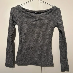 Grå ribbad offshoulder topp Shein - Grå långärmad topp från Shein i ribbat material med offshoulder-skärning. Snygg, figurnära passform och mjuk känsla. Perfekt att styla med jeans eller kjol för en trendig look. Toppen till hösten!