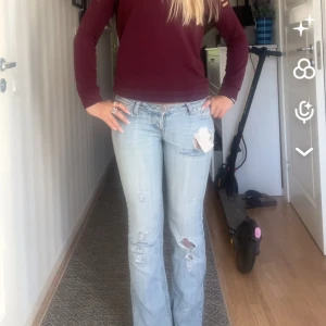 ljusblå bootcut jeans -  jeans med bootcut passform och slitna detaljer samt hål på låret och knät. Klassisk femficksmodell med röd Levis-tag på bakfickan. Jeansen har låg midja och är tillverkade i jeansmaterial av bomull. Haft håll som syns på bilden som jag har sytt igen, inte så fint sytt men syns inte när man har på sig dom