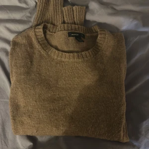 Beige/brun stickad tröja från Mango - Mysig beige/brun stickad tröja från Mango med rund halsringning och ribbade muddar. Perfekt för lager-på-lager och chill dagar. Långärmad och i mjukt material som känns skönt mot huden.