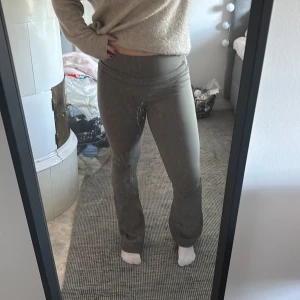 Gråa bootcut leggings från MKLIFESTYLE - Snygga grå leggings från MKLIFESTYLE med bootcut-ben och hög midja. De är stretchiga och sitter tajt upptill men släpper vid anklarna. Perfekta för dig som gillar en clean och sportig look. Materialet är mjukt och följsamt, vilket gör dem riktigt bekväma.