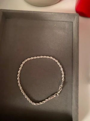 Snyggt silverfärgat armband Helt nytt - Stilrent armband i silverfärg med tvinnad kedja och klassiskt lås. Perfekt accessoar för att lyfta din outfit med en clean och modern touch. Passar både till vardags och när du vill vara lite extra.