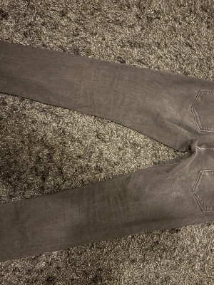 Svarta raka jeans - Säljer ett par svarta jeans med raka ben och klassiska bakfickor. Jeansen har en enkel design utan synliga detaljer eller mönster och är tillverkade i ett mjukt jeanstyg. Perfekta för dig som gillar en clean och stilren look. 32W