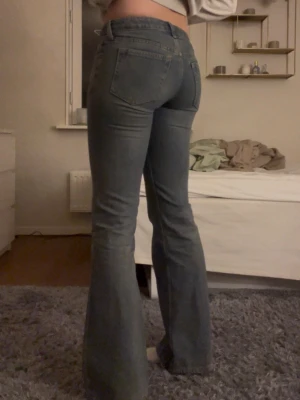 Lågmidjade weekday jeans - Säljer ett par blå lågmidjade weekday jeans. De har bootcut passform med utsvängda ben och låg midja. Jeansen är i denimtyg med fem fickor och snygga sömmar. Säljer pga lite små för mig