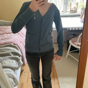 Blå kofta från Vero Moda - Mysig blå kofta från Vero Moda med v-ringning och knappar framtill. Tröjan har två fickor och ribbade muddar vid ärmslut och nederkant. Perfekt att slänga på sig över en t-shirt eller linne för en chill look. Är i Large men passar mig som har Small