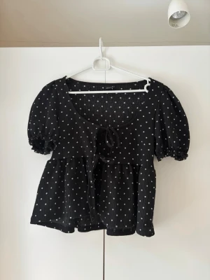 Prickig blus - Säljer denna supersöta prickiga plussen med puffärmar och rosetter. Den passar till allt och är normal i storleken. Perfekt nu till sommar💖
