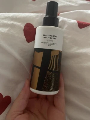 Lyko Beat The Heat Multi Spray 150 ml - Säljer en Lyko Beat The Heat Multi Spray, 150 ml. Flaskan är vit med svart och guldigt grafiskt mönster och svart spraymunstycke. Innehåller arganolja för volym och glans. Perfekt för dig som vill skydda håret mot värmeverktyg. Ca 120-130ml  kvar. Doftar såååå gott! Passa på när jag skickar med en extra liten gåva vid varje köp! 💫