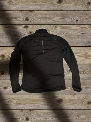 Svart vindjacka från SOC, storlek M - Säljer en svart vindjacka från SOC i storlek M. Jackan har hög krage, hel dragkedja framtill och två sidofickor. Materialet är syntet och jackan har en diskret reflexdetalj på ryggen. Perfekt för dig som vill ha en enkel och sportig look.