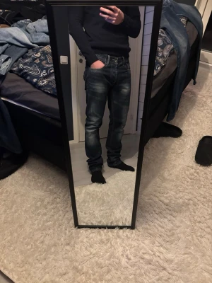 Jack & Jones mörkblå jeans - Säljer ett par jack & jones jeans i mörkblå tvätt med snygga slitningar och klassisk femficksdesign. Jeansen har normal passform och raka ben, tillverkade i mjukt jeansmaterial. Perfekta för dig som gillar en stilren och tidlös look. Jag tror att det är modellen Tim original. Storleken är 33/36 men dom är inte alls så långa som man kan tro.