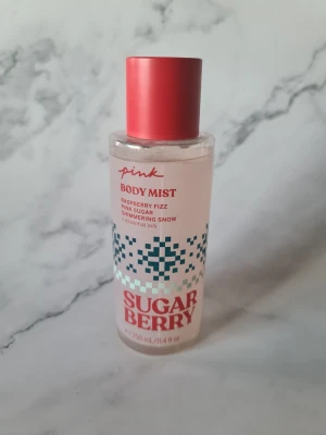 Sugar Berry Body Mist Pink - Sugar Berry Body Mist från Pink ger en fräsch känsla med inslag av raspberry fizz, pink sugar och shimmering snow. Innehåller eteriska oljor, är vegansk och dermatologiskt testad. Flaskan rymmer 250 ml och är delvis tillverkad av återvunnet material. Den där spray grejen är sönder men går att spraya ändå om man håller fast den samtidigt som man trycker. Endast testad några gånger för att säkerställa att den går att använda fortfarande. Därav priset