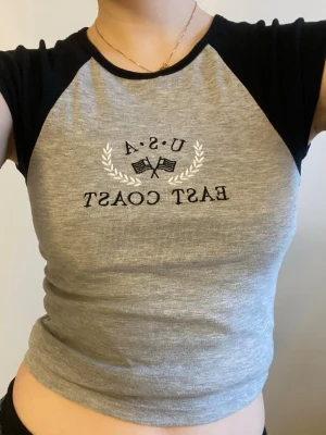 Söt tshirt från New Look - Säljer en grå t-shirt från New Look med trycket  'U.S.A EAST COAST' . Jättesöt och stilren, säljer då ja  inte använder den längre:)) storlek S men passar nog också xs