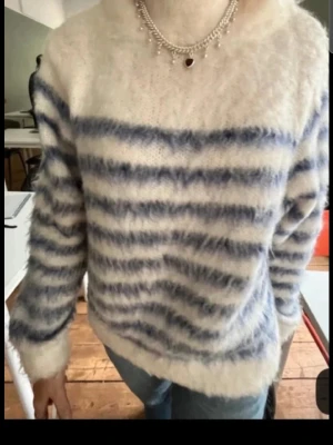 Stickad mohair tröja❤️ - Mysig fluffig stickad tröja med vita och blå ränder. Tröjan har lång ärm och en relaxed passform, perfekt för kyliga dagar. Materialet känns mjukt och gosigt mot huden och ger en avslappnad vibe.