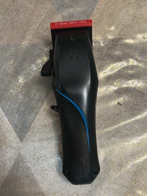 Wahl Vapor Cord/Cordless Clipper - Wahl Vapor är en professionell hårtrimmer med både sladd och sladdlös funktion. Den har en svart kropp med blå detalj, ergonomiskt grepp och F32 Fadeout-blad med 32 fina tänder för smidig klippning. Perfekt för sömlös blending och fading. Lättviktig design för enkel hantering.