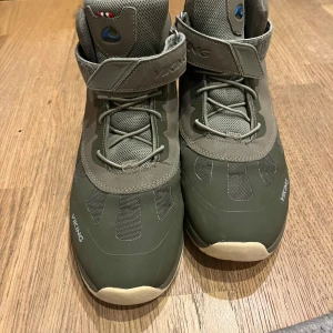 Gröna kängor från Viking - Snygga gröna kängor från Viking med robust sula och kardborreband upptill. Skorna har snörning och är tillverkade i syntetmaterial och mesh för extra andningsförmåga. Perfekta för utomhusaktiviteter under höst och vinter. Gore Tex. 