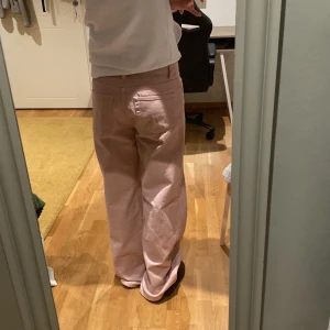Rosa wide jeans från Monki - Säljer ett par ljusrosa jeans från Monki med breda ben och klassisk femficksdesign. Byxorna har hög midja och är tillverkade i bomull. Perfekt för dig som gillar en loose och avslappnad stil. Snyggt Monki-märke baktill i brunt. Skicka om ni vill diskutera pris eller vill ha flera bilder🩷(tredje bilden ser den lite mörka ut men jeansen är mer ljusrosa)
