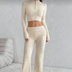 Beige stickat set🤎 - Säljer ett set med beige stickade byxor med bred ribbad midja och raka, vida ben. Byxorna har en mjuk och stretchig känsla med en matchande överdel.