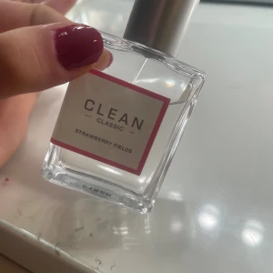 Clean Classic Strawberry Fields parfym - Clean Classic Strawberry Fields är en fräsch parfym med modern känsla. Perfekt för dig som vill ha en enkel och stilren doft i vardagen. Snygg och minimalistisk flaska som passar in i alla badrum.