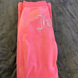 Rosa Juicy Couture Byxor - Säljer ett par snygga rosa mjukisbyxor från Juicy Couture i mjukt velour material.🩷Skriv gärna privat om mer bilder önskas🙏.