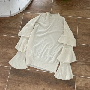 Stickad tunn tröja med volanger  - Från six ames i storlek M. Finns en liten fläck 