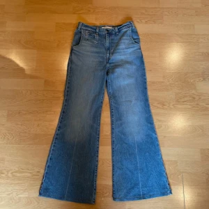 Ribcage bell jeans  - Säljer ett par klassiska Ribcage Bell jeans i blå denim med bootcut passform. Dom är uppsydda så att dom passar mig som är 159cm lång och är storlek 26 i midjan. Dem är använda runt 8 gånger så de är i bra skick 