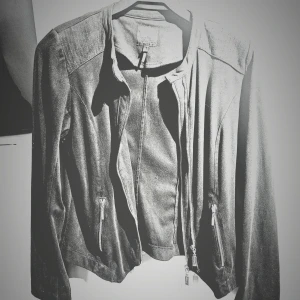 Svart bomber/ mc jacka från Yest, strl 38 - Snygg svart tunn bomberjacka i mocca  från Yest med coola silverfärgade dragkedjor framtill och vid fickorna. Jackan har lång ärm, rundad hals och diskreta sömdetaljer på axlarna. Materialet känns mjukt och jackan har en modern, lite kortare passform.