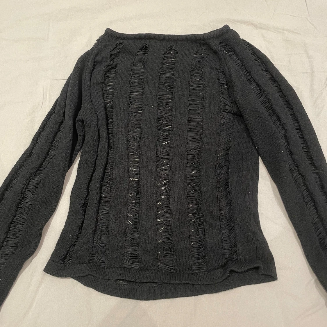Svart stickad tröja med slitsade detaljer