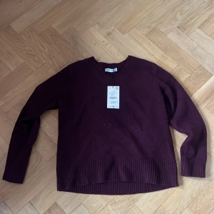 Vinröd stickad tröja från Zara - Mysig vinröd stickad tröja från zara med v-ringad hals.