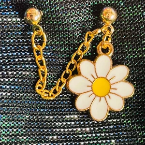 By prisförslag- 1 st dubbelt örhänge med blomma - Superfint örhänge med kedja i guldfärg och en stor blomma som hänge. Blomman har vita kronblad och en gul mitt, vilket ger en söt och lekfull känsla. Perfekt accessoar för dig som vill sticka ut med något färgglatt och charmigt.