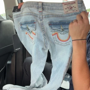 Assnygga True Religion Jeans ( FAST PRIS) - Säljer nu mina jättefina True Religion byxor då jag köpte i fel storlek. De är i modellen Joey ( lågmidjade ) och har en cool och unik färg på fickorna! Hör av er om fler bilder!💕 De är i w25