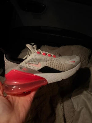 Nike Air Max 270 sneakers neon rosa - Nike Air Max 270 sneakers vit med neon rosa superfina men för små för mig, har inte använt så mycket kanske 5 gånger utomhus sedan några gånger på gymmet men haft dom i 3år men typ inte använda, ej tvättade men blir nog helt rena om man lägger in i maskinen! Storlek 37,5. Nypris 1800kr 