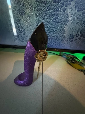 Good Girl Eau de Parfum 80ml - Cool och unik parfymflaska i form av en glittrig lila klack. Innehåller 80 ml Eau de Parfum. Tillverkad i Spanien. Perfekt för dig som vill sticka ut med din stil. Carolina herrera limited edition flaska, innehållet är samma som orginal good girl allså den svart mörkblåa flaskan, det som är annorlunda ba med denna är flaskans design, dena vara har jag ba sprutat me några ggr så den är nästan helt full, eftersom jag har lukten i orginal flaskan så har jag två av denna lukt o säljer denna.