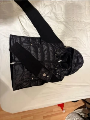 Svart dunväst från Moncler med huva - Köpt på plick satt för stor så nu vill jag sälja den. Storlek M helt nu fraktas inom 24h. Kontakta vid frågor. Pris kan diskuteras