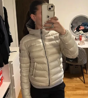 Colmar pufferjacka vit - Säljer en ljus beige/ vit pufferjacka från Colmar med huva. Jag köpte den själv på Vinted men nu säljer jag vidare för att den var för liten. Den är lagad på tre ställen på ena ärmen. Skriv gärna om frågor! 💝
