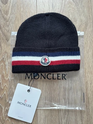 Moncler mössa  - Helt ny svart Moncler mössa. Finns fler spännande artiklar på profilen!!