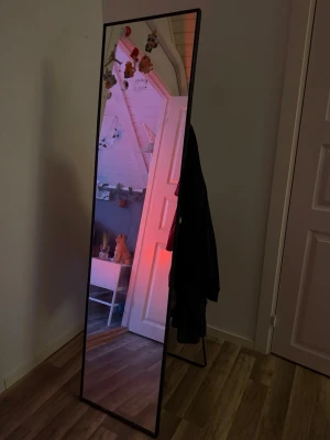 Svart spegel  - Spegel med fot eller vad de heter så den kan stå utan att sättas upp på väggen, den kan även sättas upp på väggen med två skruvar. Den har fem krokar på baksidan, de sitter klistermärken på den som jag håller på att ta bort och blir inga märken efter den som jag ser nu, skriver såklart om de är märken efter dom. Vet inte hur lång och bred den är men tar reda på de om nån är intresserad, fler bilder kan skickas. 